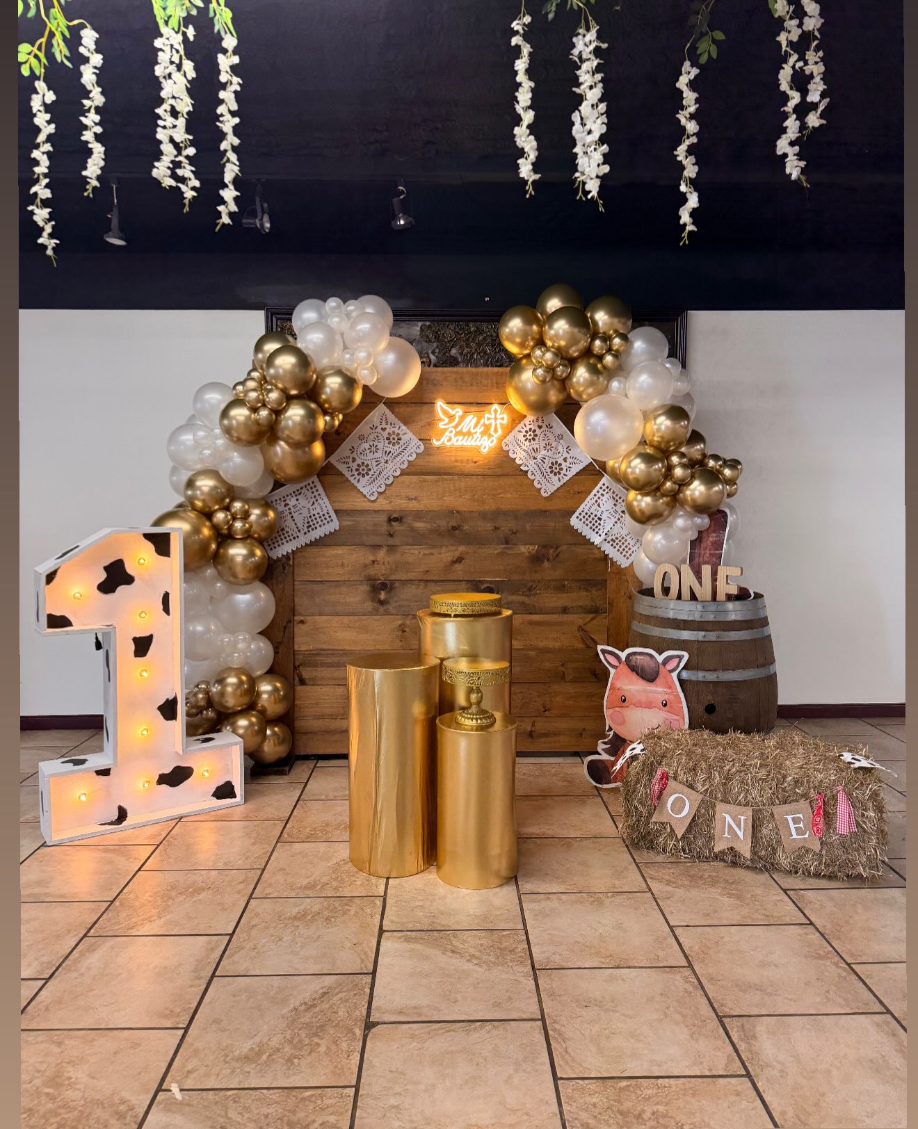 Decoración de primer cumpleaños de estilo vaquero con globos dorados y marrones